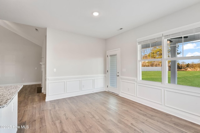 spare room with wainscoting and wood finished floors