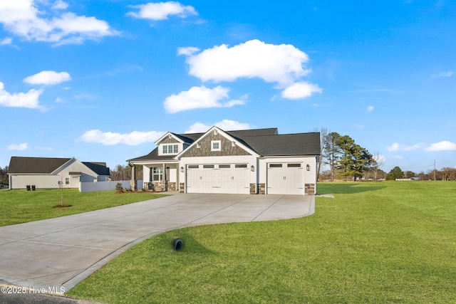 view of front of property featuring an attached garage, stone siding, driveway, and a front yard