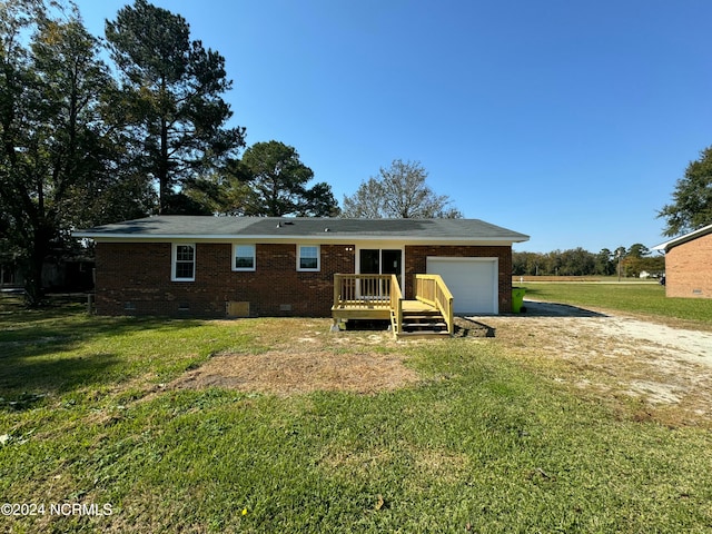 back of house featuring a lawn and a garage