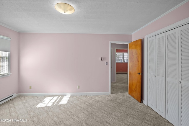 unfurnished bedroom featuring ornamental molding, light carpet, a textured ceiling, and a closet