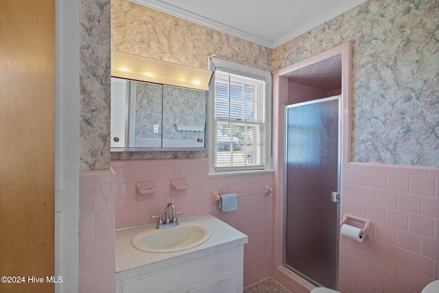 bathroom featuring vanity, tile walls, and a shower with shower door