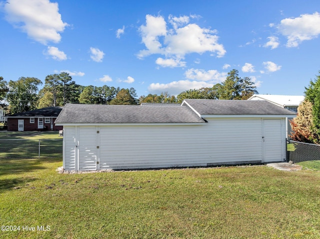 view of side of property with a yard and a shed