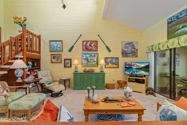 living room featuring stairway, carpet floors, and wood walls