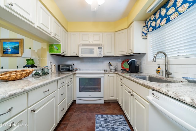 kitchen with tasteful backsplash, a sink, a toaster, white cabinets, and white appliances