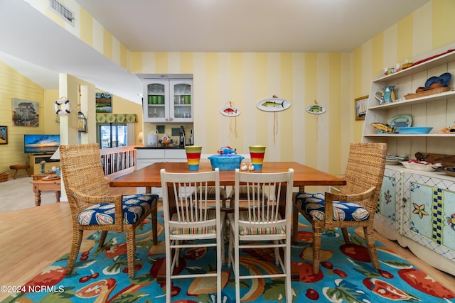dining area featuring wallpapered walls, visible vents, and wood finished floors