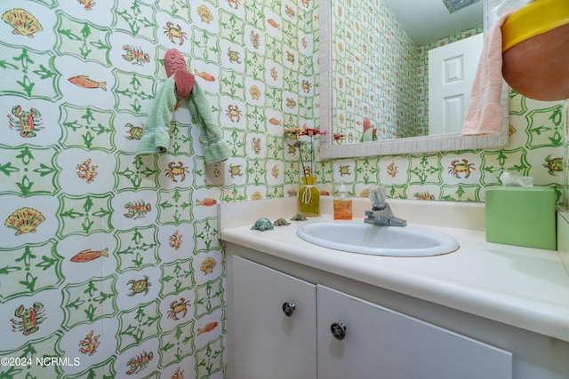 bathroom with vanity and wallpapered walls
