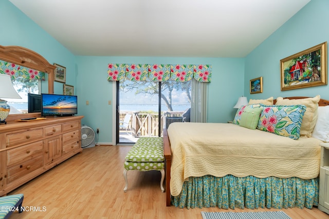 bedroom with multiple windows, light wood-type flooring, and access to outside