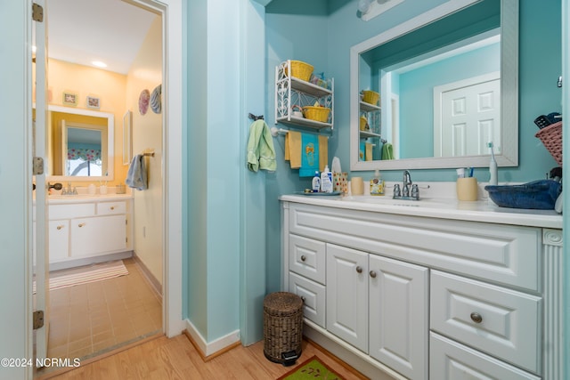 bathroom with vanity, baseboards, and wood finished floors