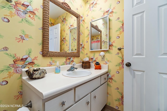 bathroom featuring vanity and wallpapered walls