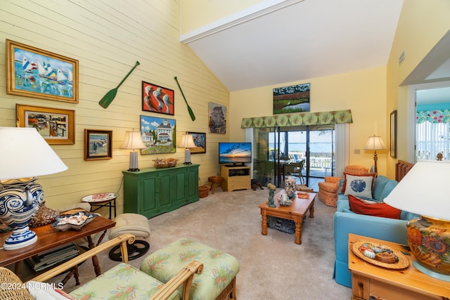 carpeted living room with high vaulted ceiling and wood walls