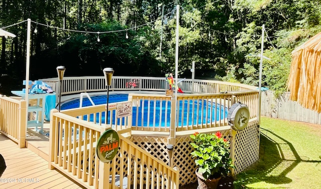 view of pool featuring a wooden deck and a yard