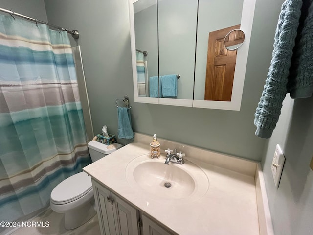 bathroom featuring vanity, curtained shower, and toilet