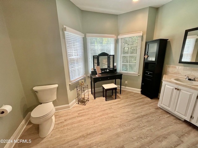 bathroom with vanity, toilet, and hardwood / wood-style floors