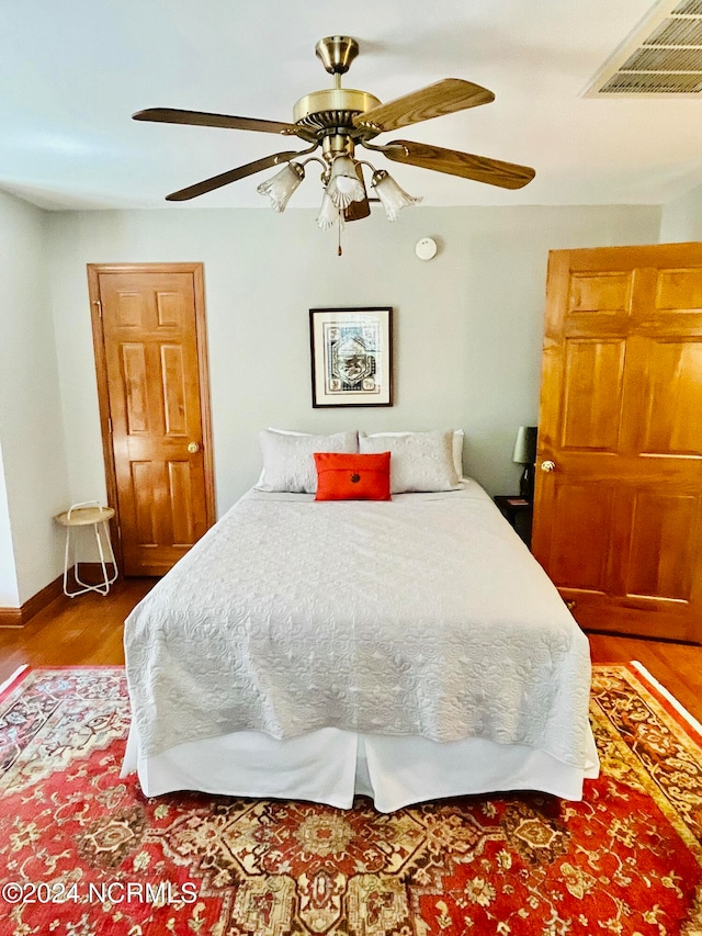 bedroom with ceiling fan and wood-type flooring