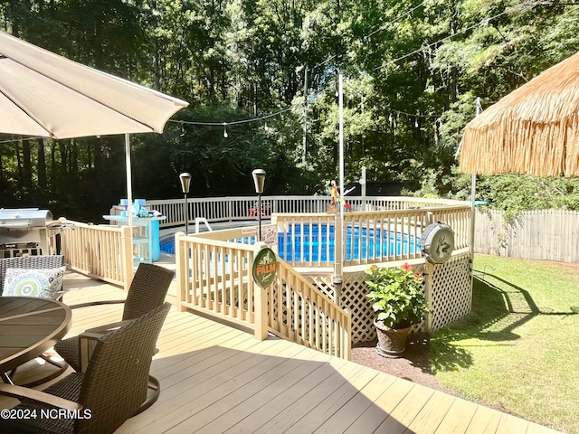 view of swimming pool featuring a deck and a lawn