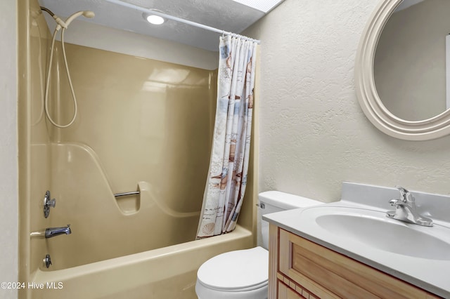 bathroom with a textured wall, vanity, toilet, and shower / bath combo with shower curtain