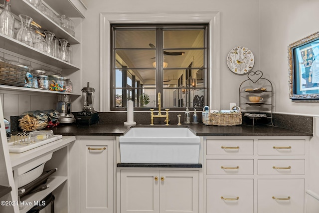 bar featuring white cabinets and sink