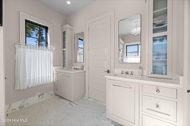 bathroom featuring vanity, a healthy amount of sunlight, a chandelier, and tile patterned floors