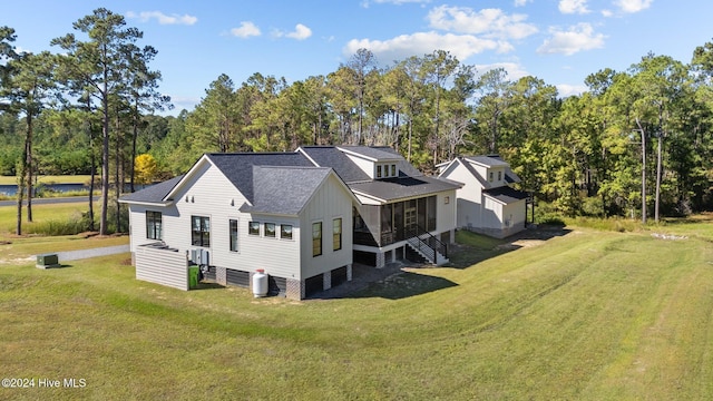 back of house featuring a sunroom and a lawn