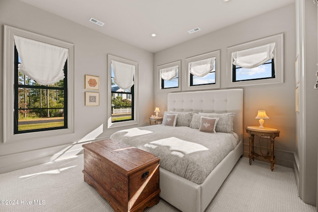 bedroom with light carpet and multiple windows