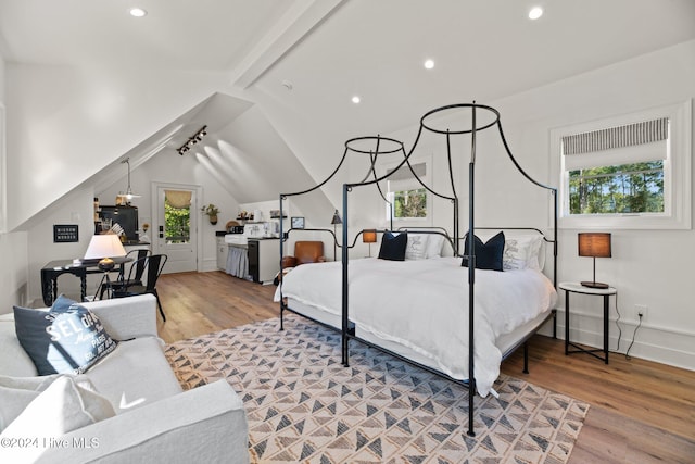 bedroom featuring lofted ceiling with beams and light hardwood / wood-style floors