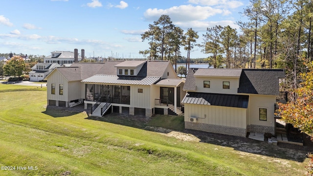 rear view of property with a yard and a sunroom