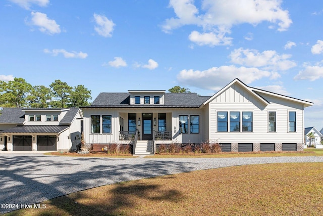 view of front of property with a front yard, a garage, and a porch