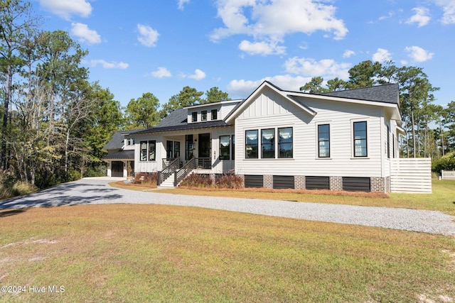 view of front of home with a garage, a front lawn, and a porch