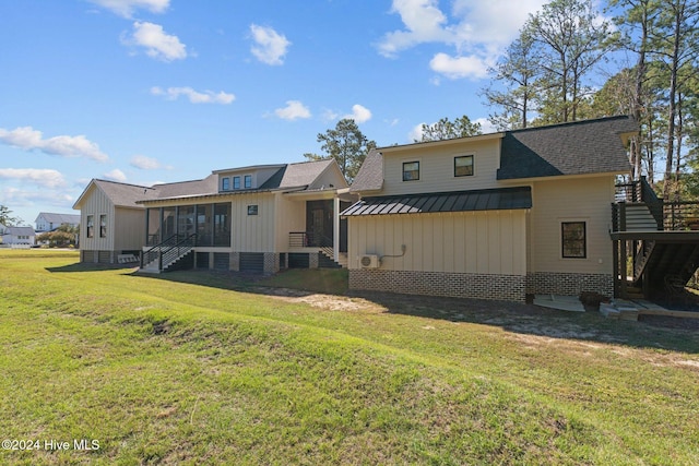 back of house featuring a yard and a sunroom