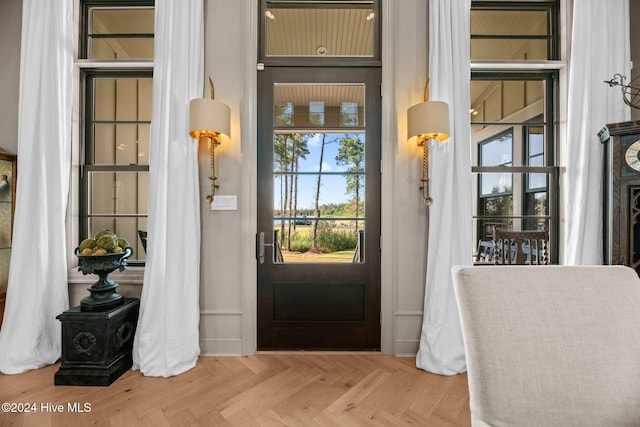 foyer entrance with parquet flooring and a healthy amount of sunlight