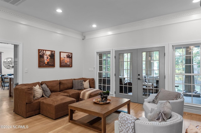 living room featuring light hardwood / wood-style floors, crown molding, and french doors