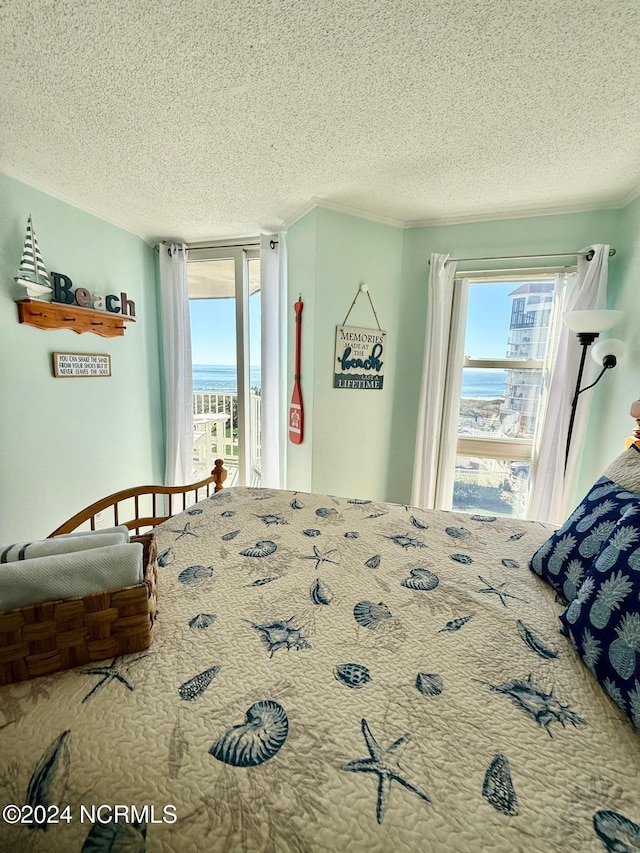 bedroom featuring access to outside, a textured ceiling, and a water view