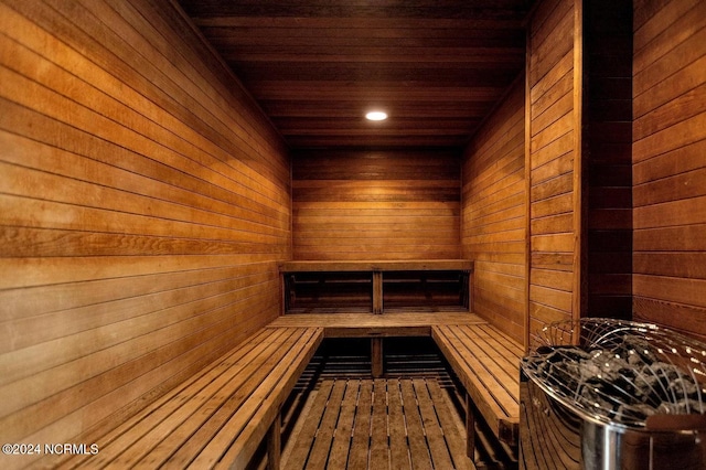 view of sauna featuring wood ceiling and wood walls