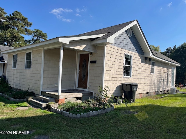 view of front of home with a front lawn and central AC unit