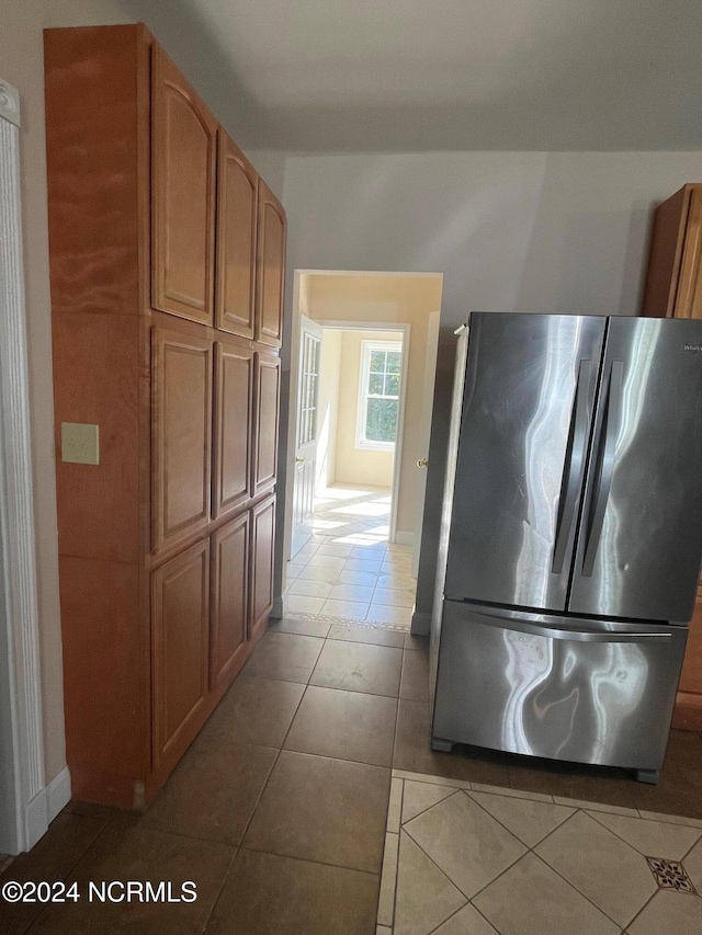 kitchen with light tile patterned floors and stainless steel refrigerator