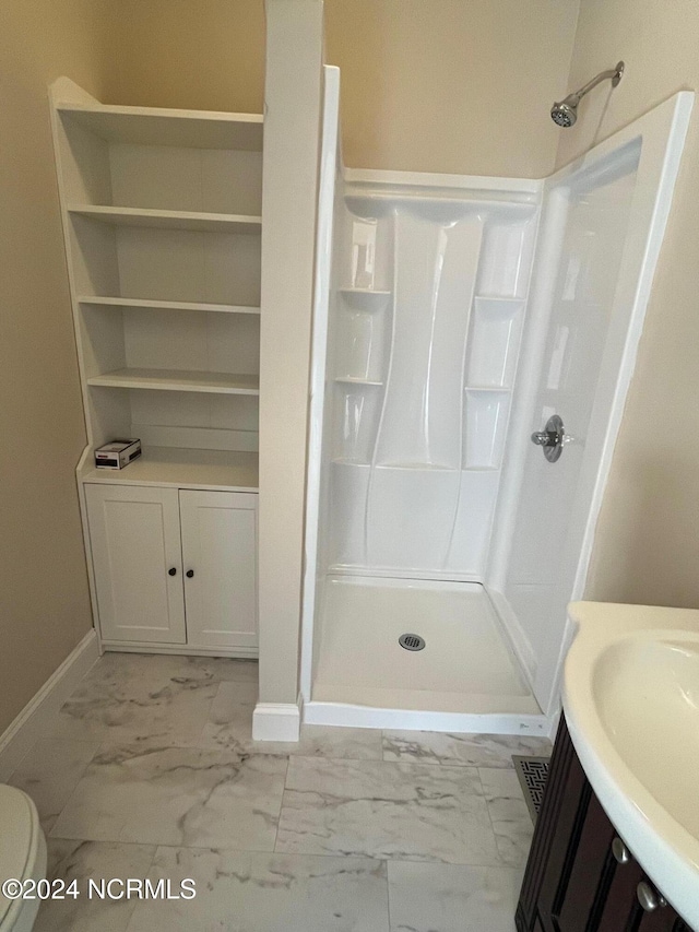 bathroom featuring vanity, toilet, and walk in shower