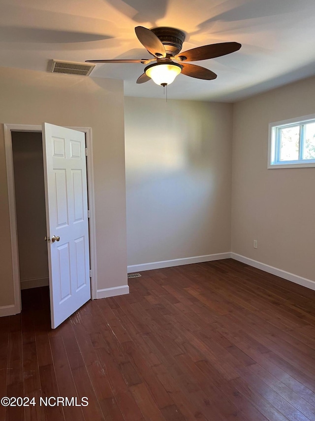 spare room featuring dark wood-type flooring and ceiling fan