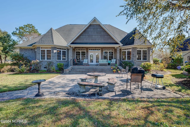 back of property with a patio, french doors, an outdoor fire pit, and a lawn