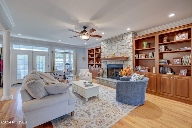 living room with light hardwood / wood-style floors, ornamental molding, and ornate columns