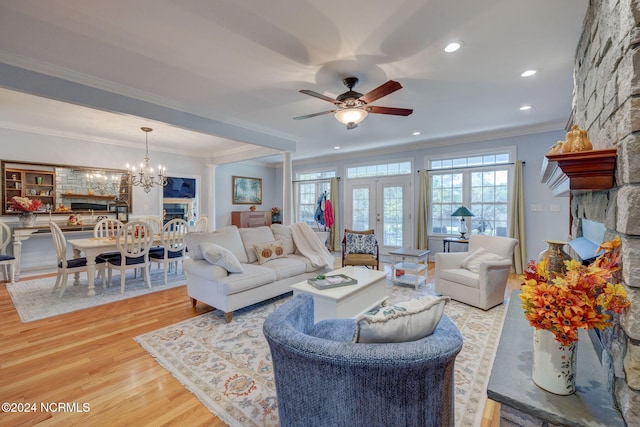 living room featuring french doors, hardwood / wood-style flooring, ornamental molding, and ceiling fan with notable chandelier