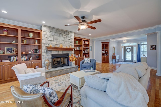 living room featuring crown molding, light wood-type flooring, and a fireplace