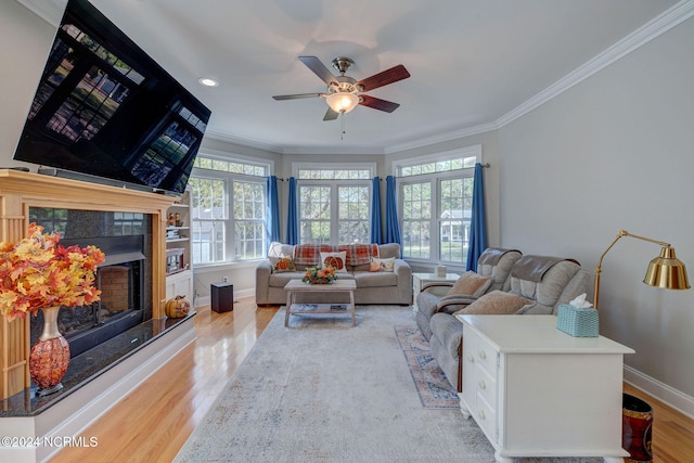 living room with ornamental molding, light hardwood / wood-style flooring, and ceiling fan