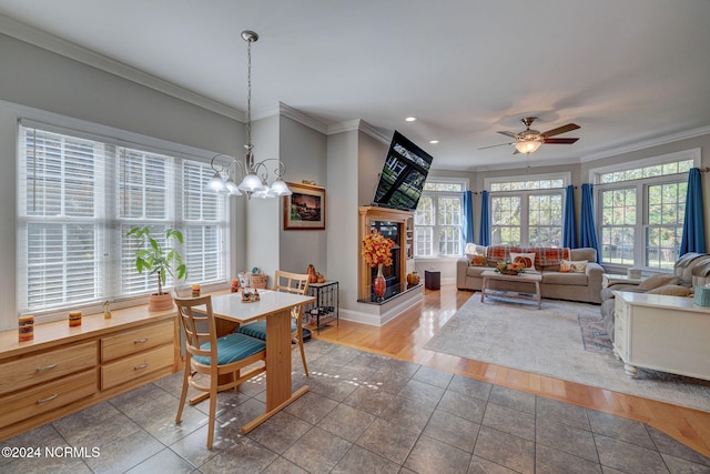 dining space featuring ornamental molding, hardwood / wood-style floors, and ceiling fan with notable chandelier