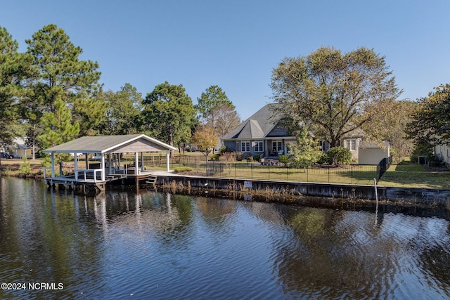 dock area with a water view and a lawn