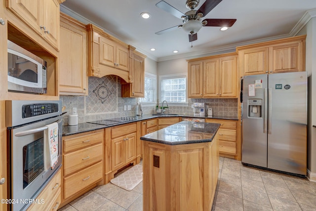 kitchen with sink, a center island, stainless steel appliances, and dark stone counters