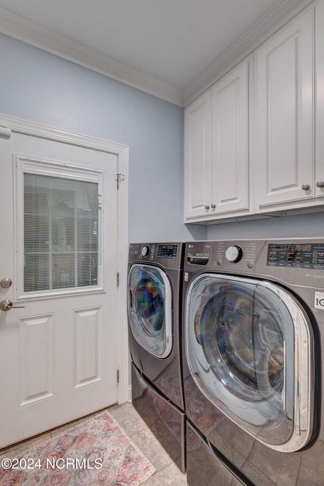 washroom with cabinets, ornamental molding, light tile patterned flooring, and washer and dryer