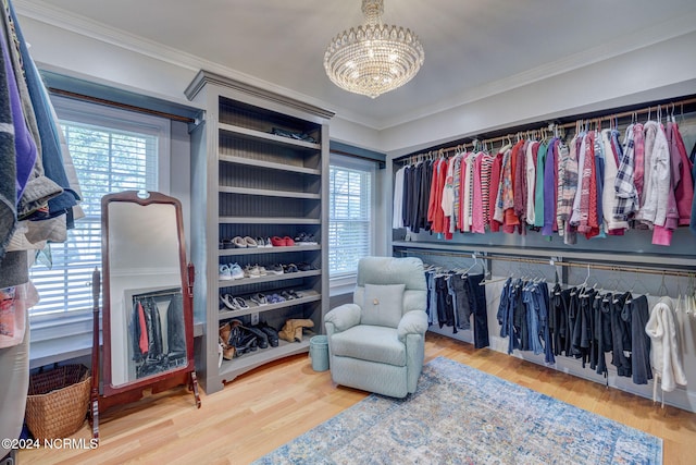 spacious closet with a chandelier and hardwood / wood-style floors