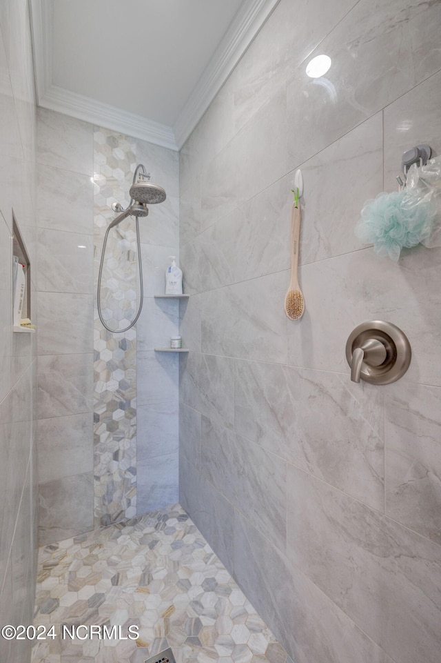 bathroom featuring tiled shower and crown molding