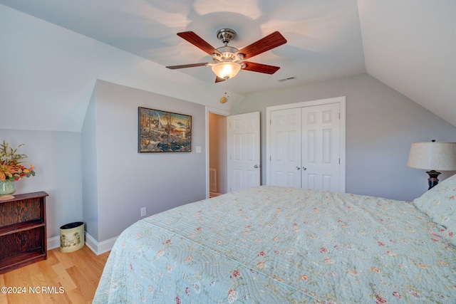 bedroom with a closet, vaulted ceiling, light wood-type flooring, and ceiling fan