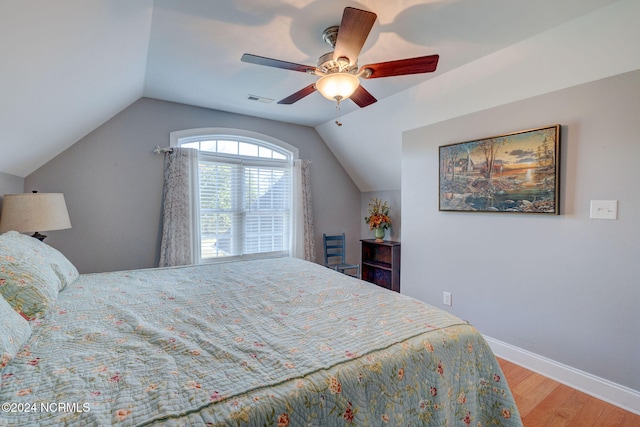 bedroom with ceiling fan, vaulted ceiling, and hardwood / wood-style floors